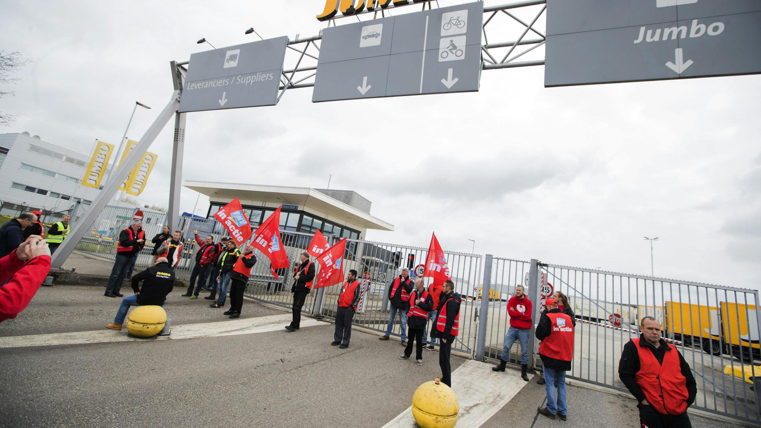 Stakende werknemers van Jumbo-distributiecentra blokkeren de toegangspoort bij de vestiging in Woerden. 
