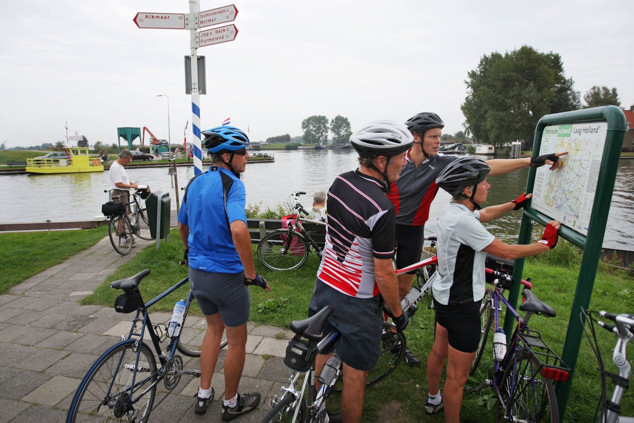 Fietsers kijken op de kaart waar ze heen gaan als ze met het pontje "Jan Hop" bij Spijkerboor overgezet zijn.