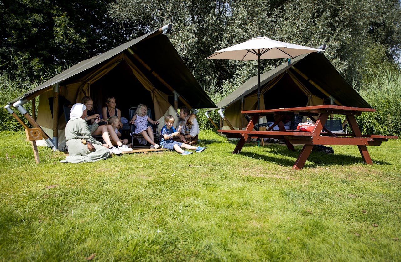 Een gezin wordt bij hun tent in het Archeon vermaakt door acteurs. Het Museumpark biedt deze zomer een driedaagse expeditie met overnachtingen en activiteiten waarbij de gasten even terug in de tijd gaan. ANP SEM VAN DER WAL