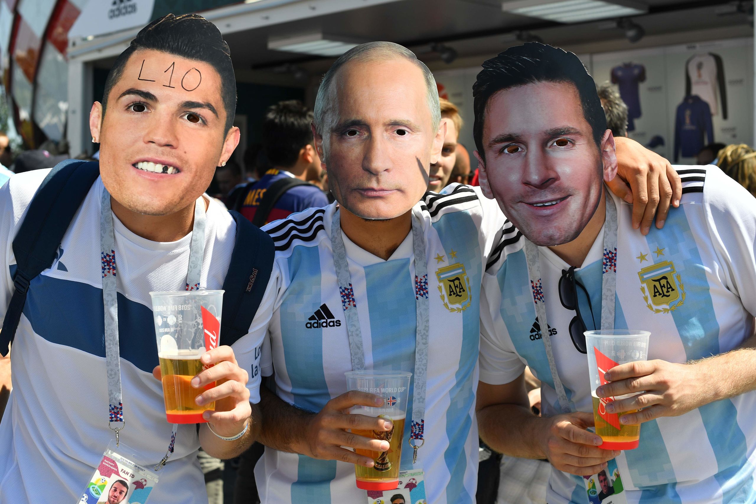 Voetbalfans met maskers van Ronaldo, Poetin en Messi bij het Spartak Stadion in Moskou.
