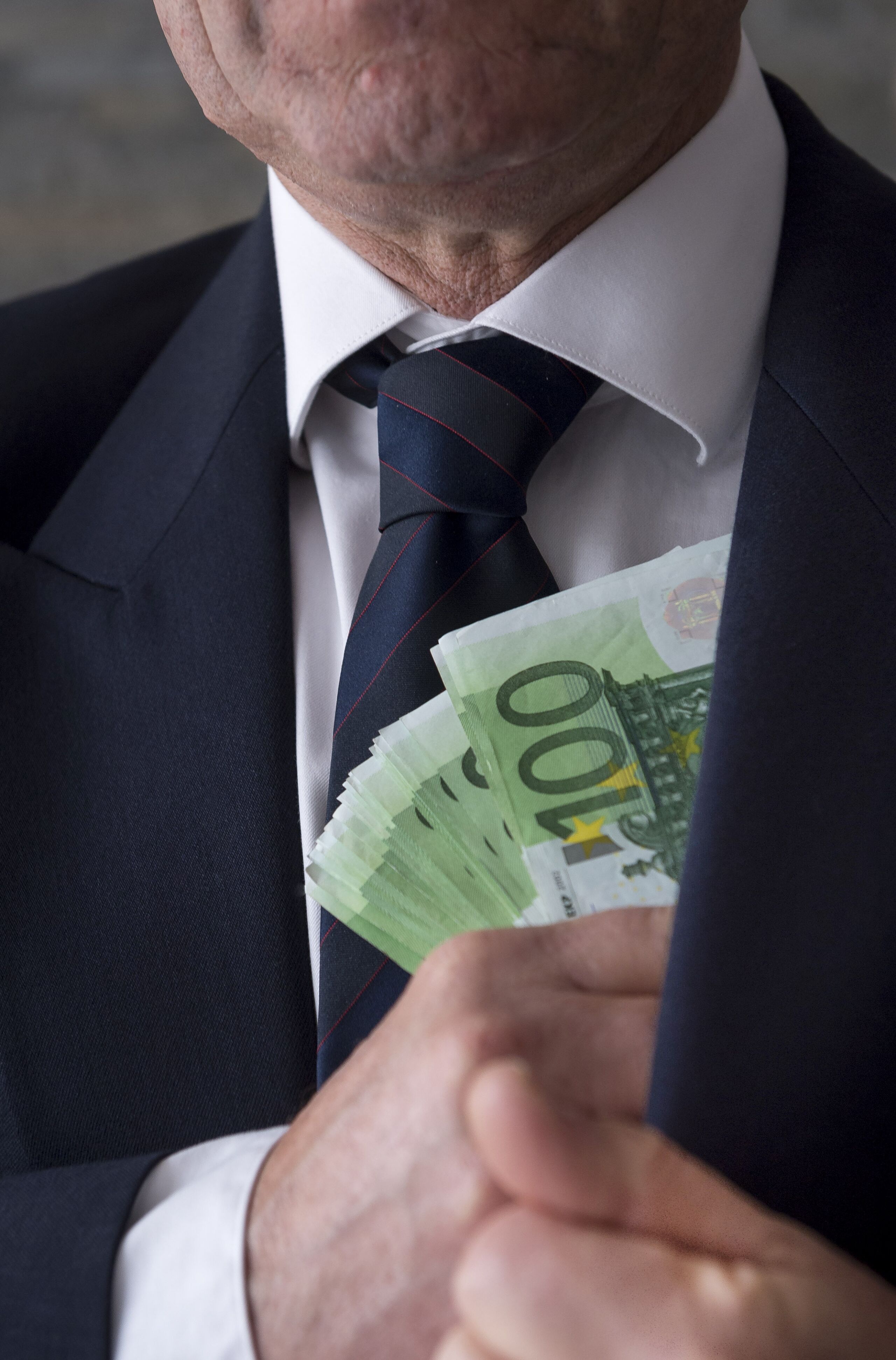 Een zakenman met een stapel van honderd eurobiljetten