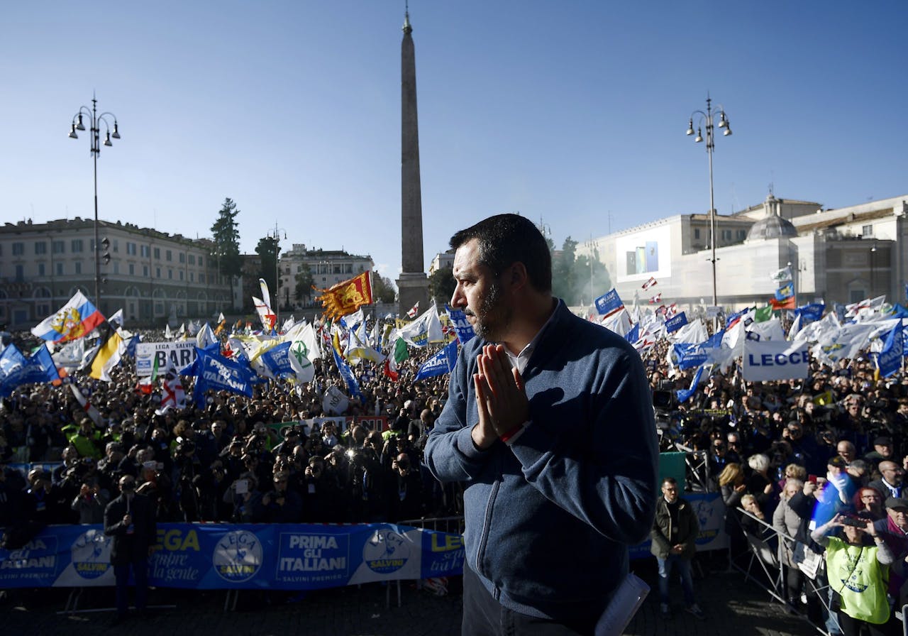 Lega party leader and Interior Minister Matteo Salvini (C) waves to supporters during a protest against European Union officials at Piazza del Popolo on December 8, 2018 in Rome. - Salvini spoke to thousands of supporters in a packed square in Rome as his surging League party celebrates six months in power. Organisers said around 80,000 people attended -- many travelling from around the country -- waving flags and banners with slogans such as "Italians first", "Italy raises its head" and "Six months of common sense government". (Photo by FILIPPO MONTEFORTE / AFP)