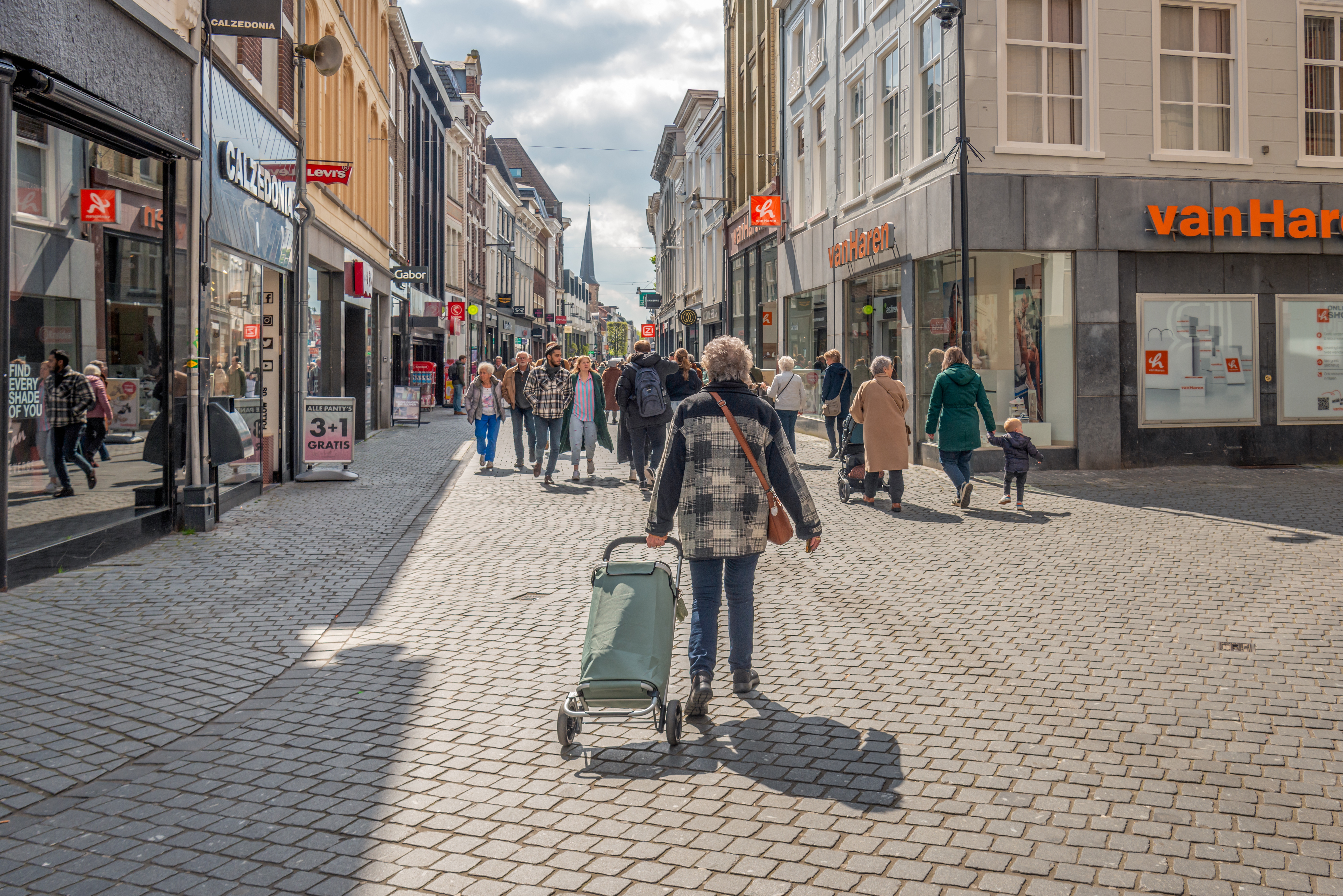 Una vista dell'Eindstraat nel centro di Breda in una fresca ma soleggiata giornata primaverile.  In primo piano c'è una donna anziana che cammina con un carrello della spesa.  ANP/Hollands Hoogt/Rud Morin