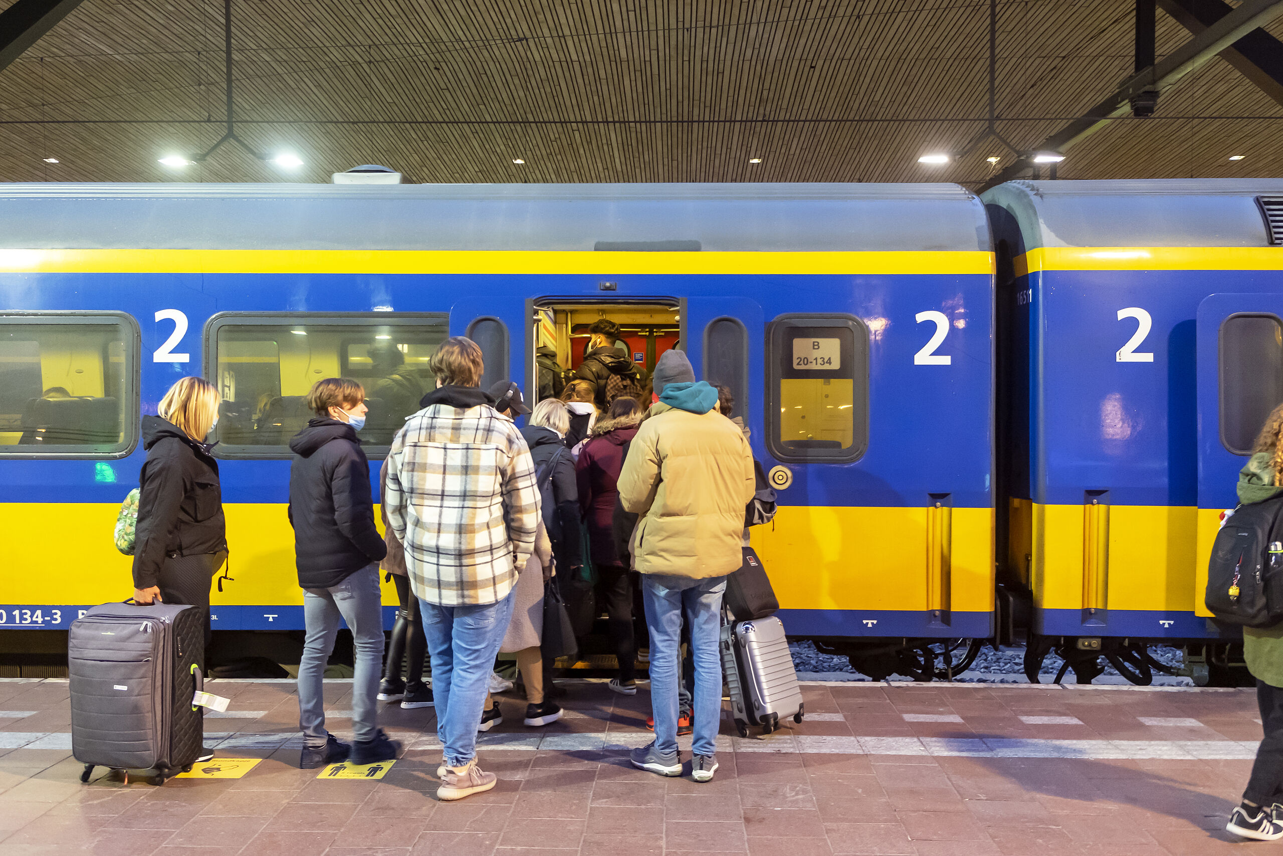 Passagiers stappen in en uit de sneltrein op Rotterdam Centraal.