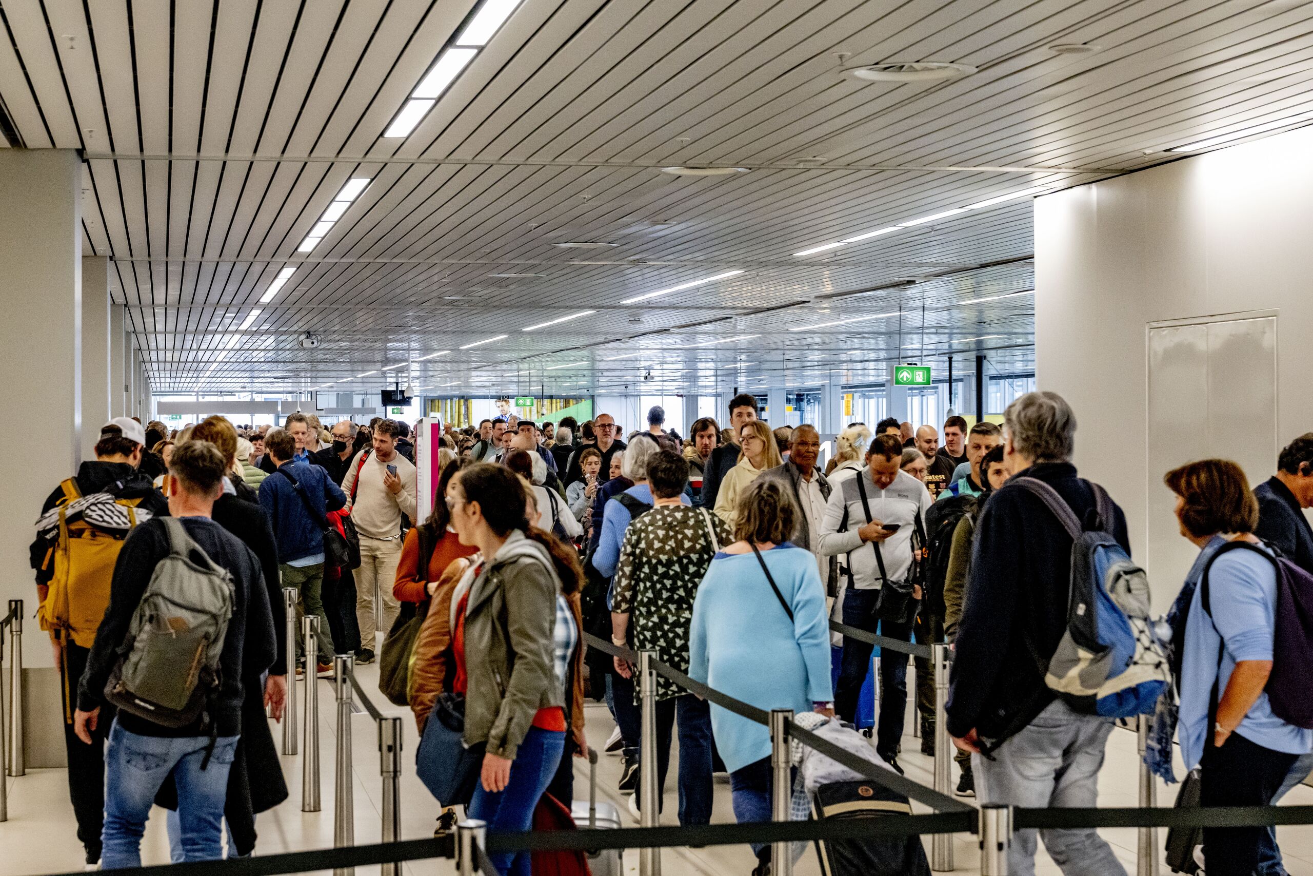 Reizigers staan te wachten in lange rijen om te vliegen vanaf Schiphol. De luchthaven waarschuwt inmiddels onomwonden dat het de komende weken tot urenlange rijen kan komen. De komende tijd is het ongeveer net zo druk als tijdens de meivakantie.