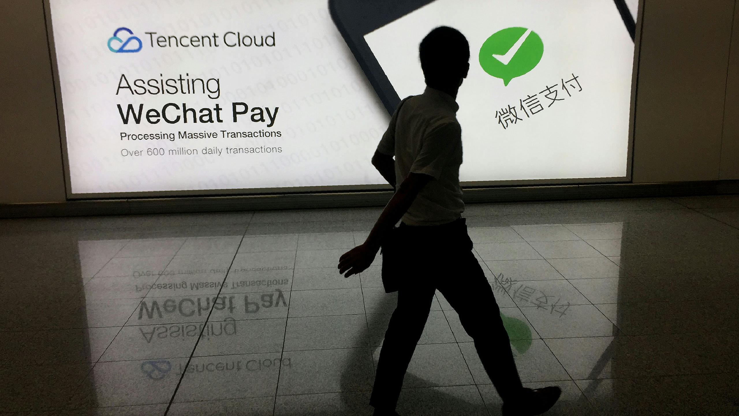 Een man loopt voorbij een advertentie van het social media-platform 'WeChat', van het Chinese bedrijf Tencent in Hong Kong.
