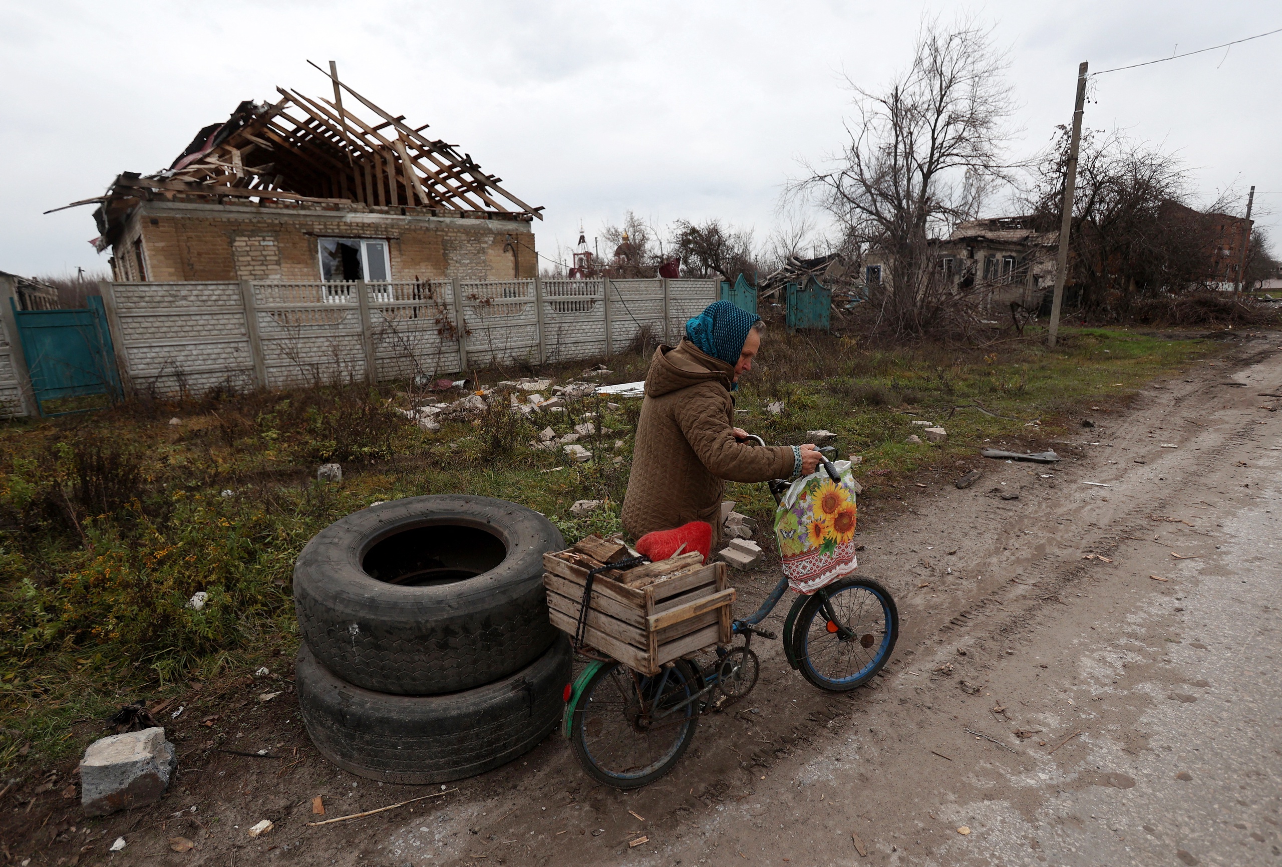 Een inwoner van het dorp Drobysheve in de regio Donetsk verzamelt brandhout.