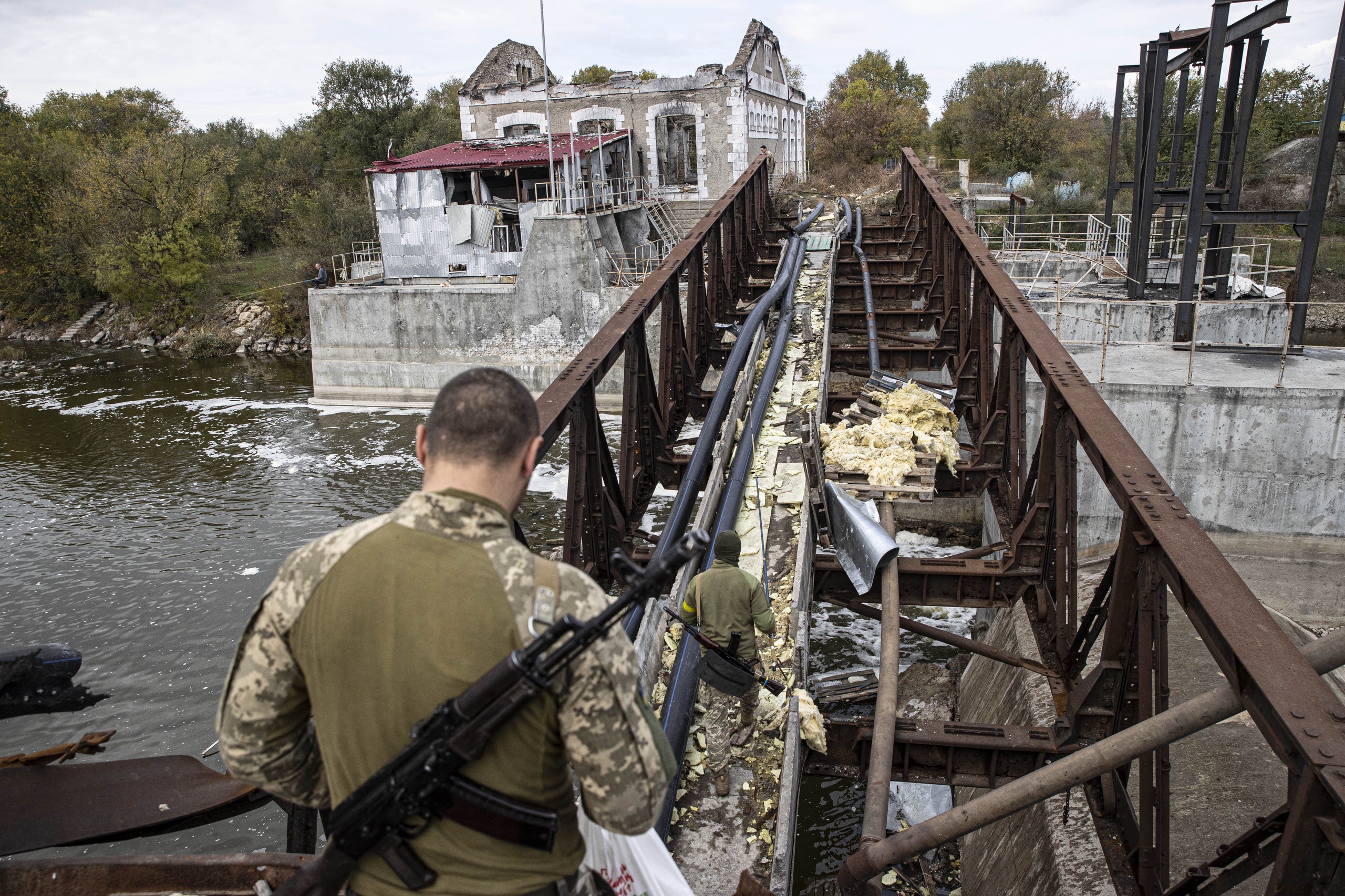 Oekraïense soldaten steken een vernietigde brug over in de regio Cherson.