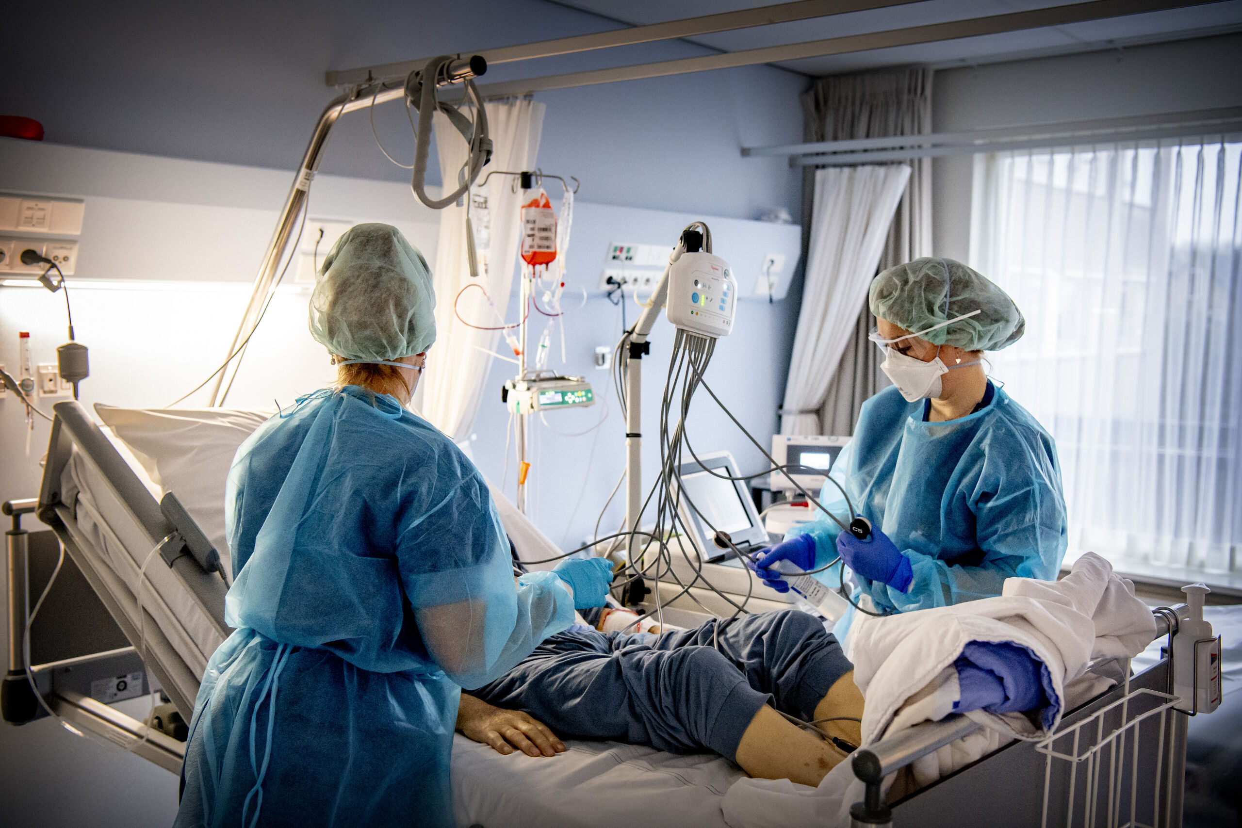 Verpleegkundigen behandelen een coronapatiënt op de coronaafdeling.