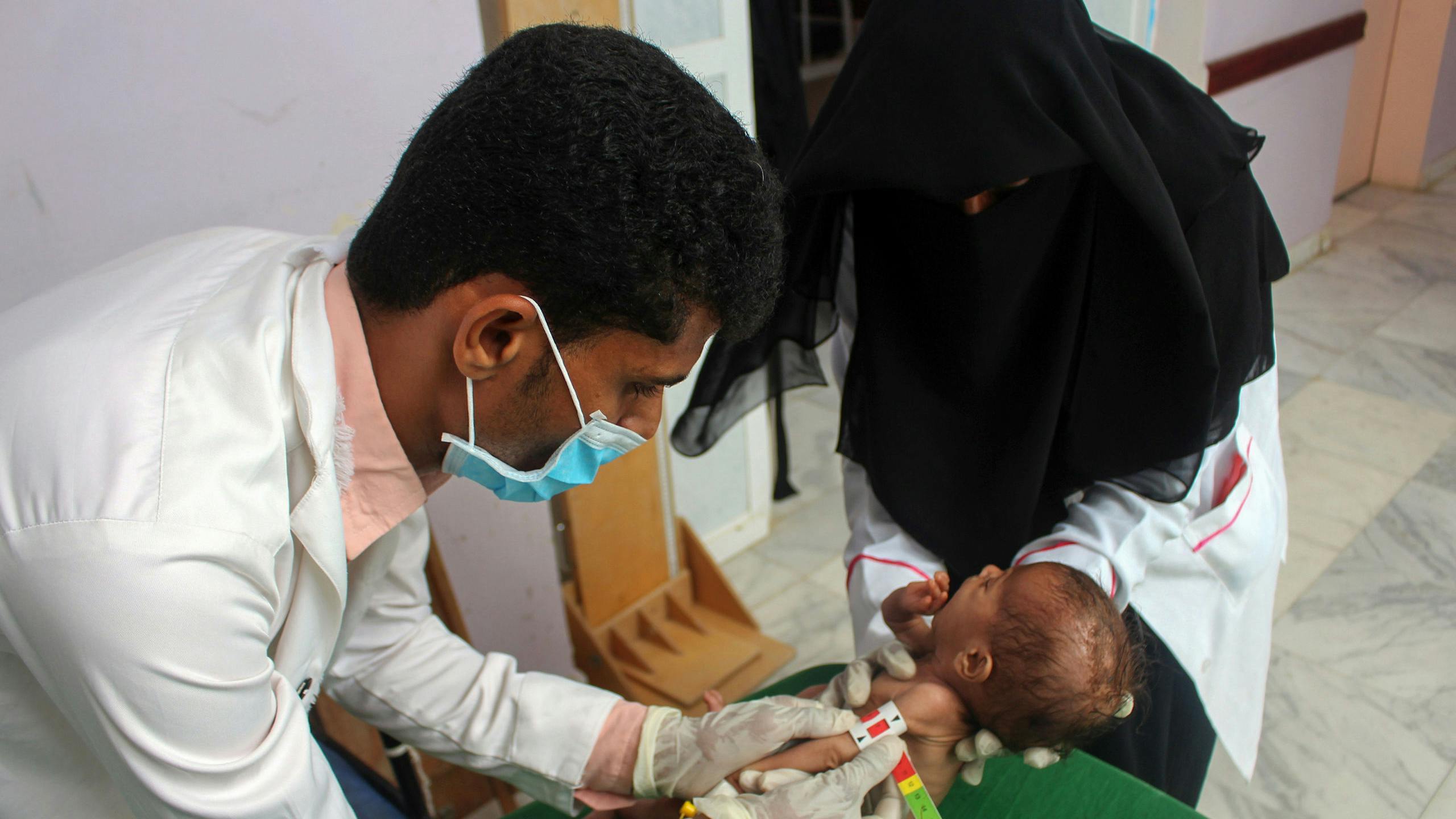 Een ondervoed kind uit Jemen wordt onderzocht door medisch personeel.