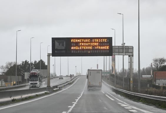 2020-12-21 13:37:25 A truck drives by a sign indicating the border closure from England