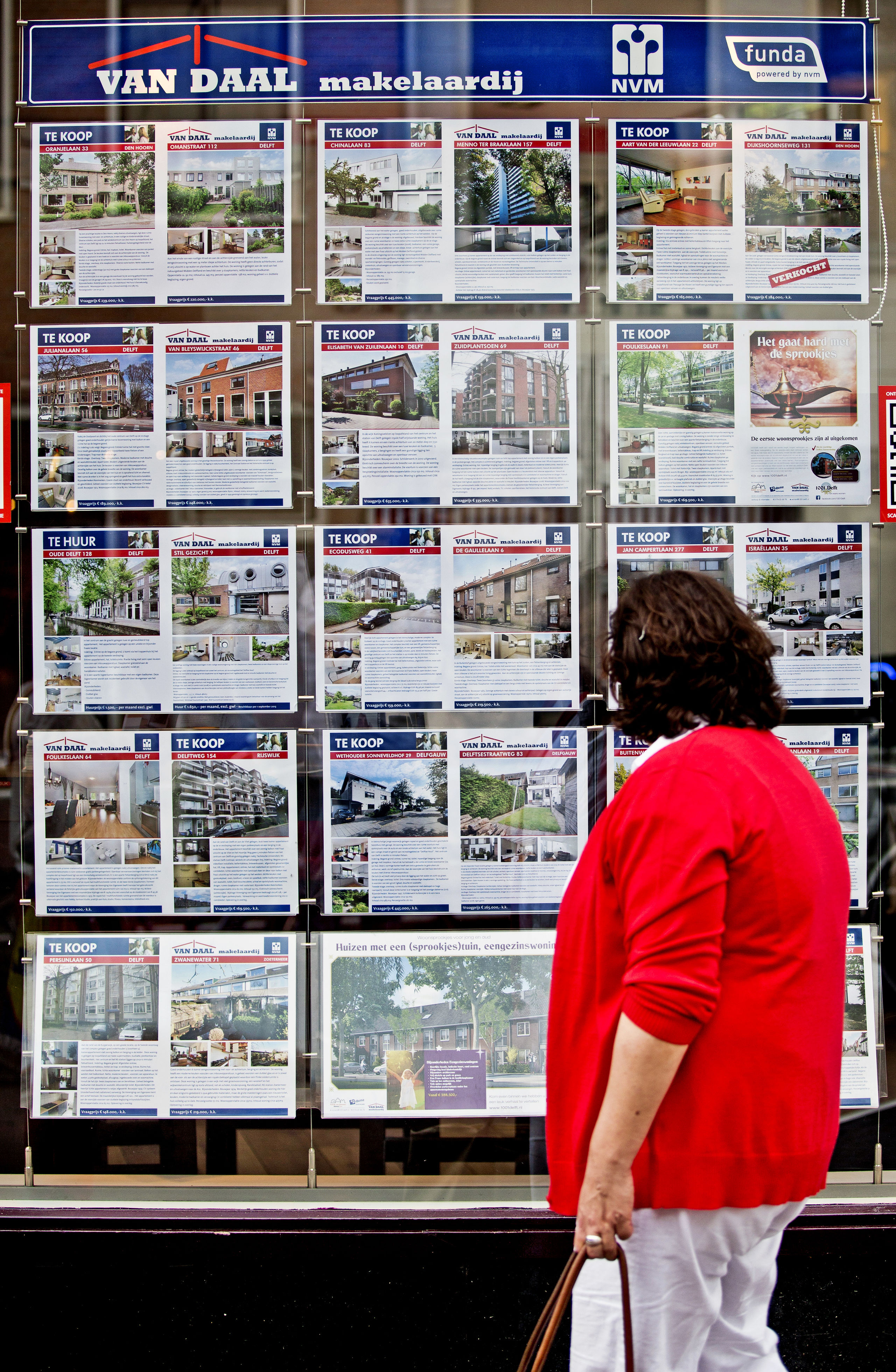 Een passant bekijkt het woningaanbod