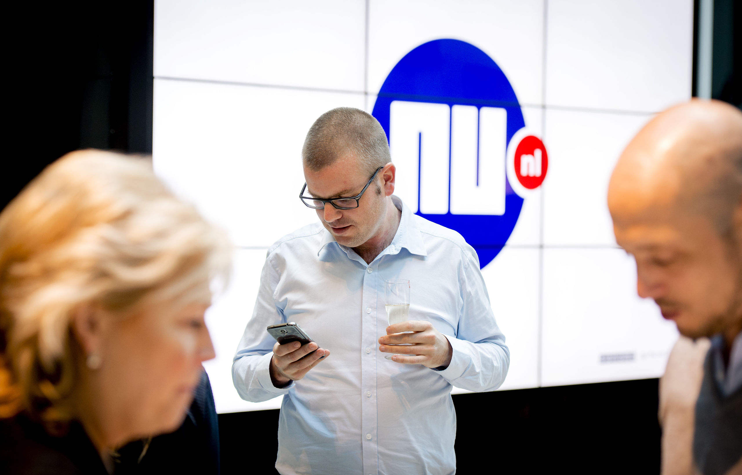 Hoofdredacteur Gert-Jaap Hoekman bekijkt de nieuwe app op zijn telefoon na de lancering van de vernieuwde NU.nl site.