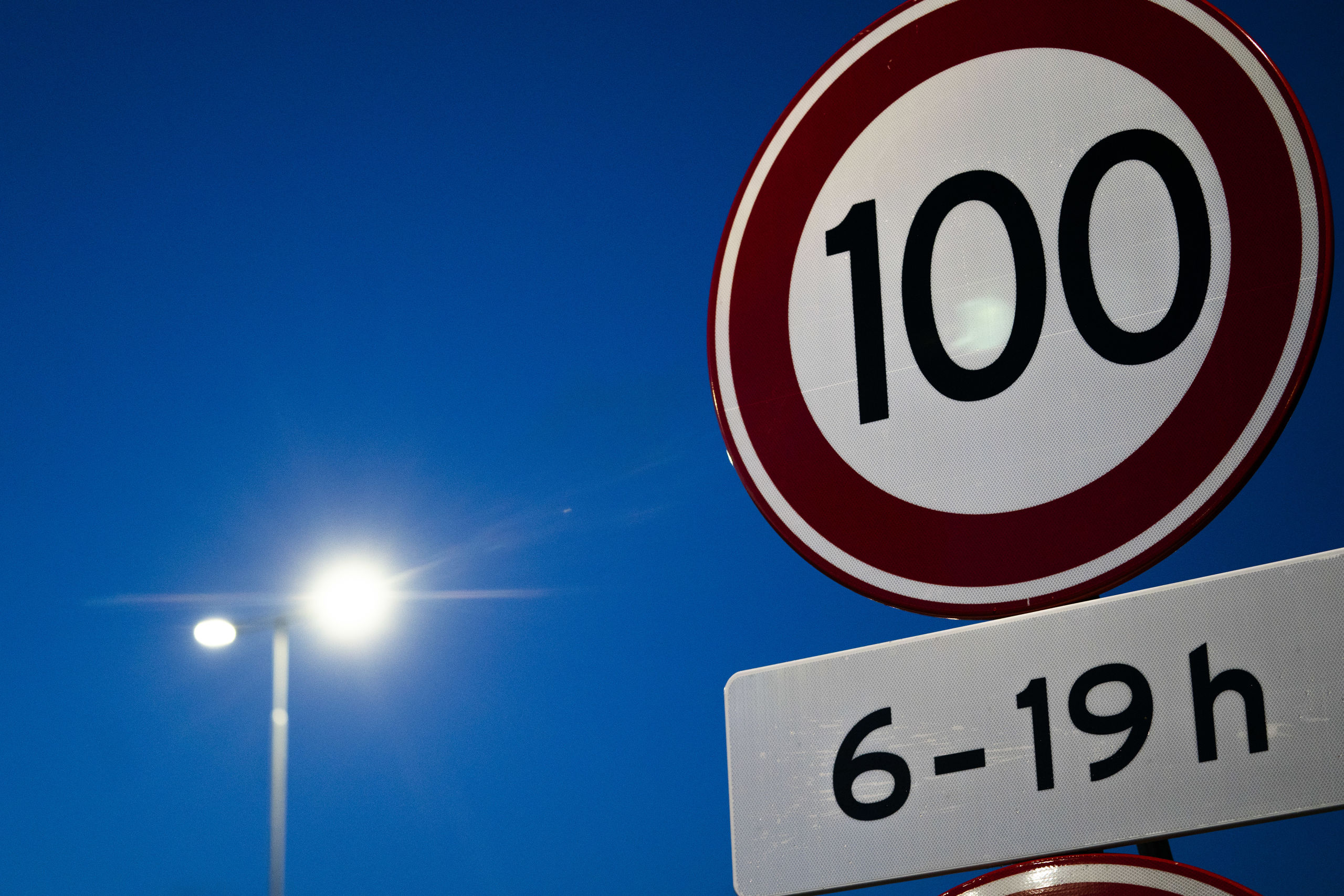 Verkeer rijdt over de A27 langs een 100 kilometer-bord.