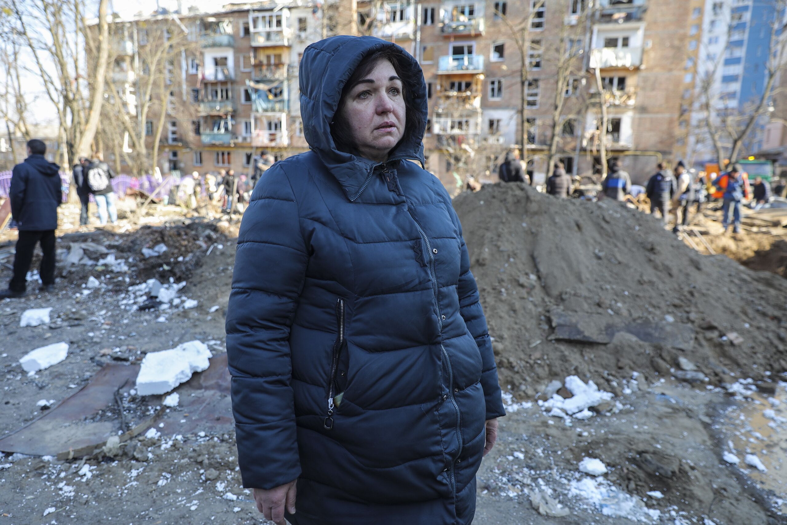 Huilende vrouw in beschadigde woonwijk