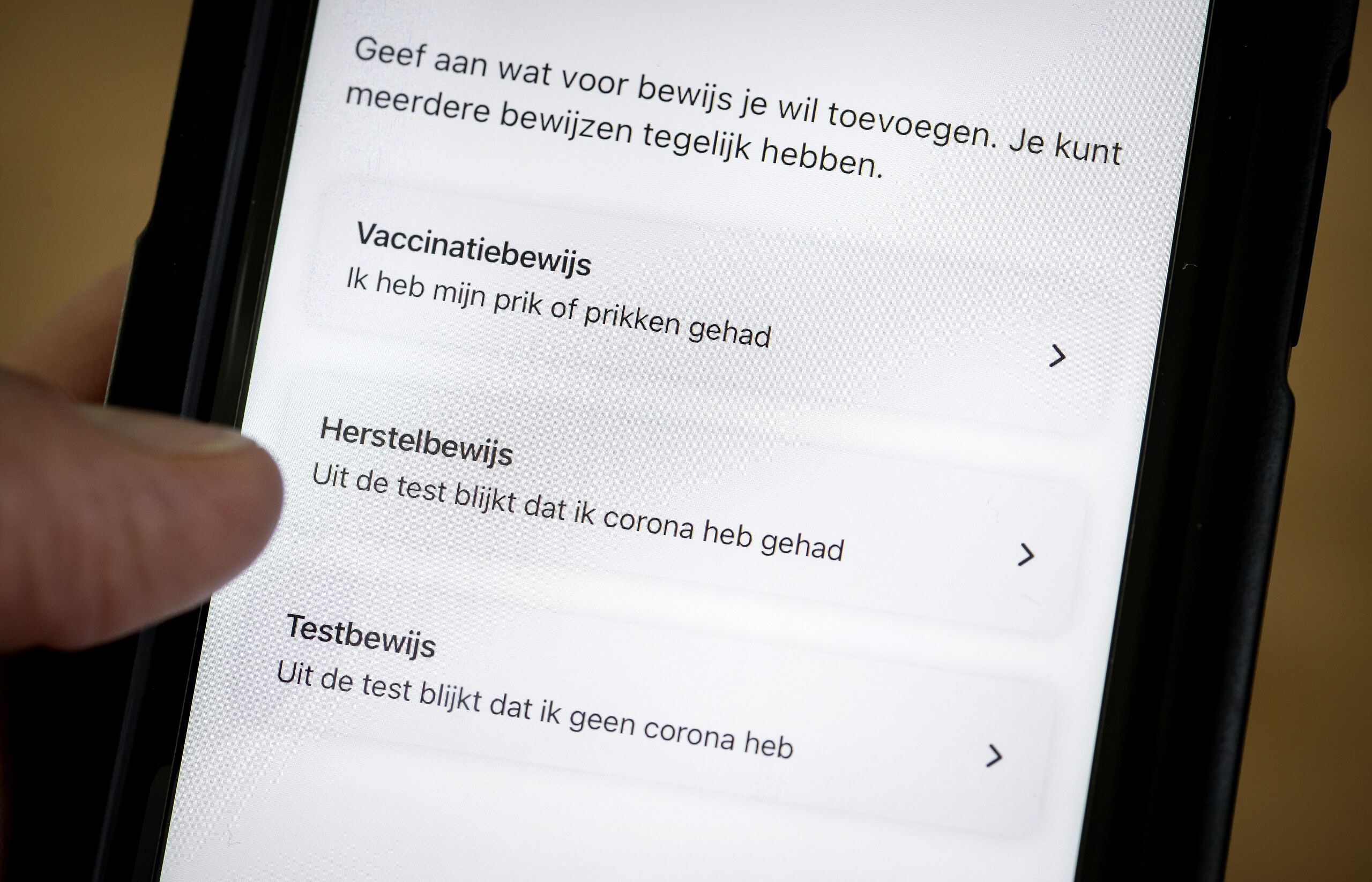 ILLUSTRATIEF - Een mobiele telefoon met de CoronaCheck app. Het demissionaire kabinet wil het mogelijk maken dat mensen in de 2G-aanpak alleen een QR-code krijgen na een vaccinatie (Gevaccineerd) of als zij hersteld zijn van corona (Genezen). Een negatieve test is dan niet meer voldoende om een groen vinkje te krijgen. ANP KOEN VAN WEEL