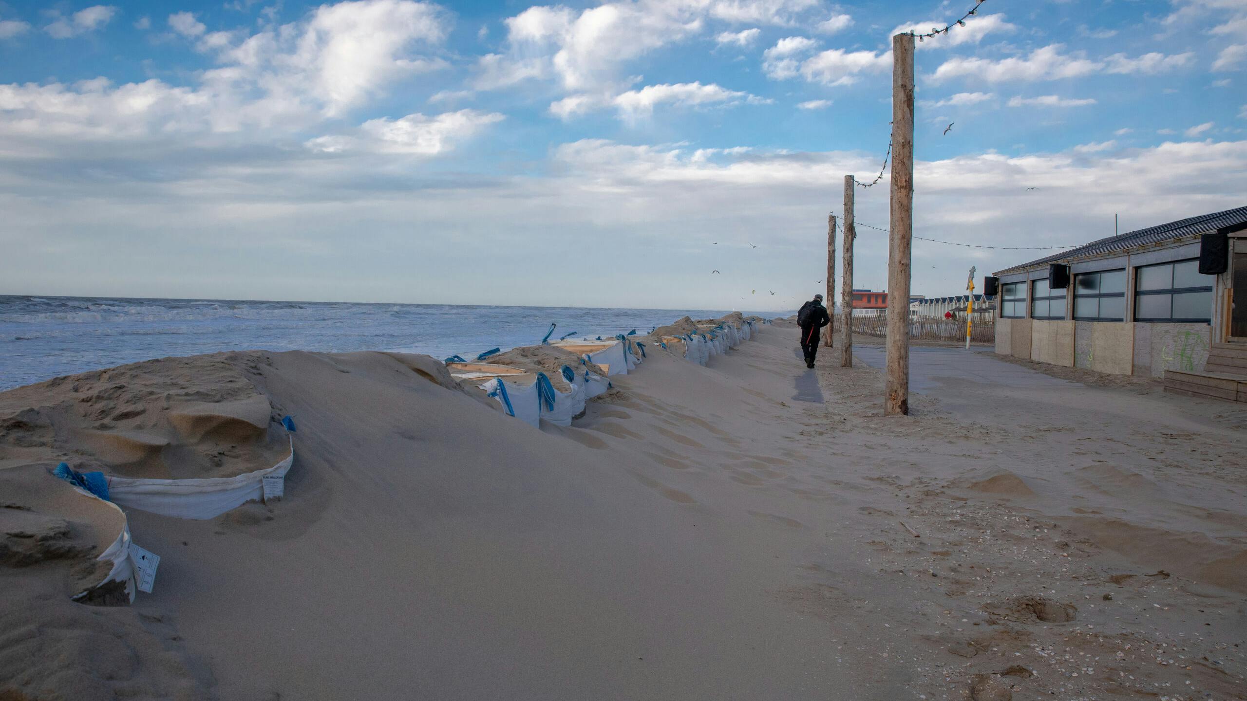 Katwijk aan Zee- Door het hoge water staat het strand deels onder water. Strandtent eigenaren zijn bezig om hun tenten storm klaar te maken.