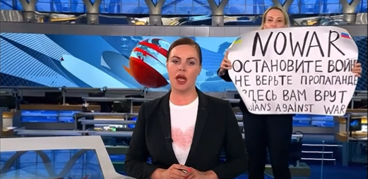 Marina Ovsjannikova die een uitzending van haar voormalige werkgever onderbreekt om een statement tegen de oorlog af te geven.
