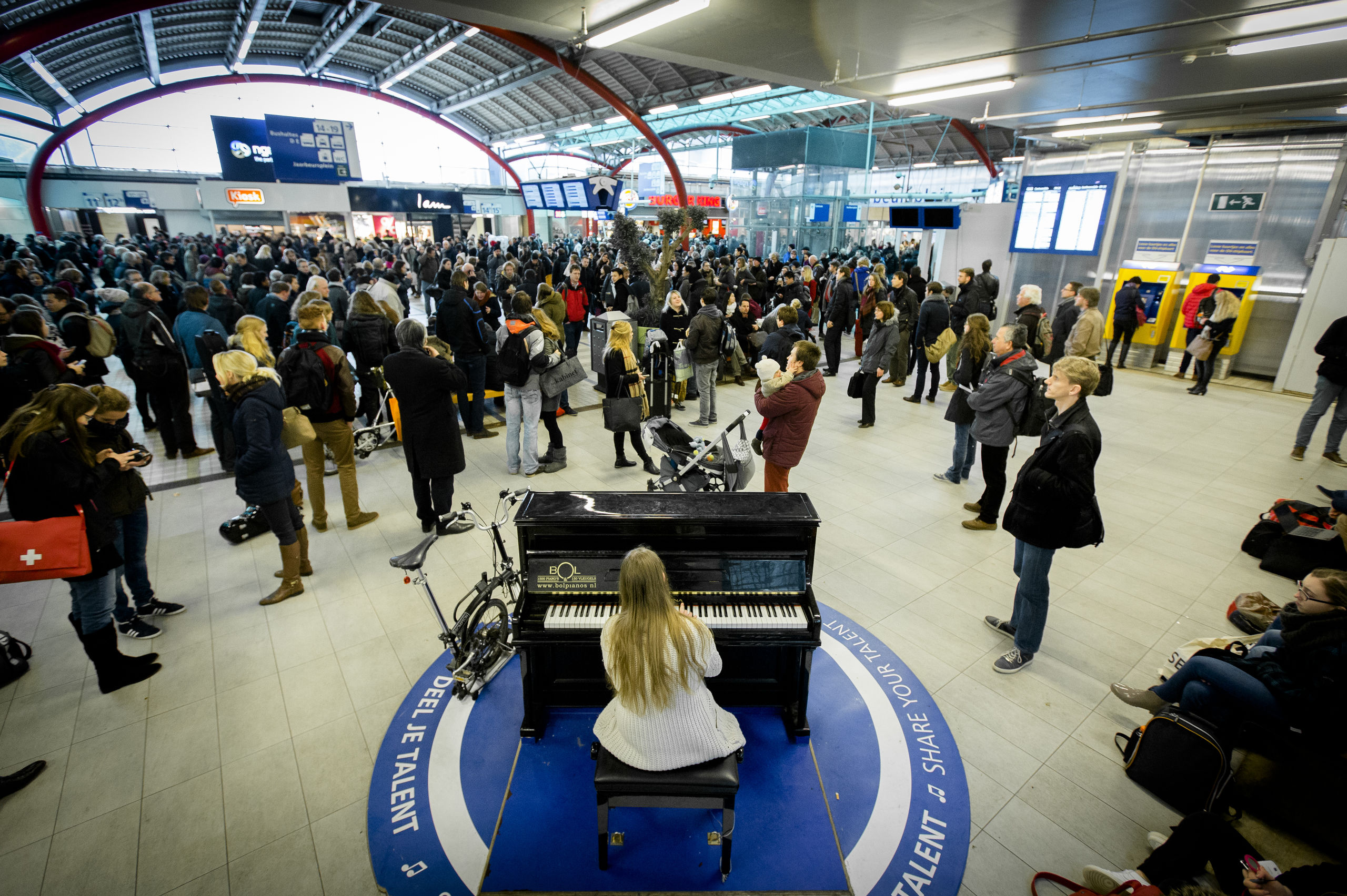 De stationspiano kan ook voor verlichting zorgen als het even niet meezit: door een storing kwamen deze reizigers vast te zitten op Utrecht CS.