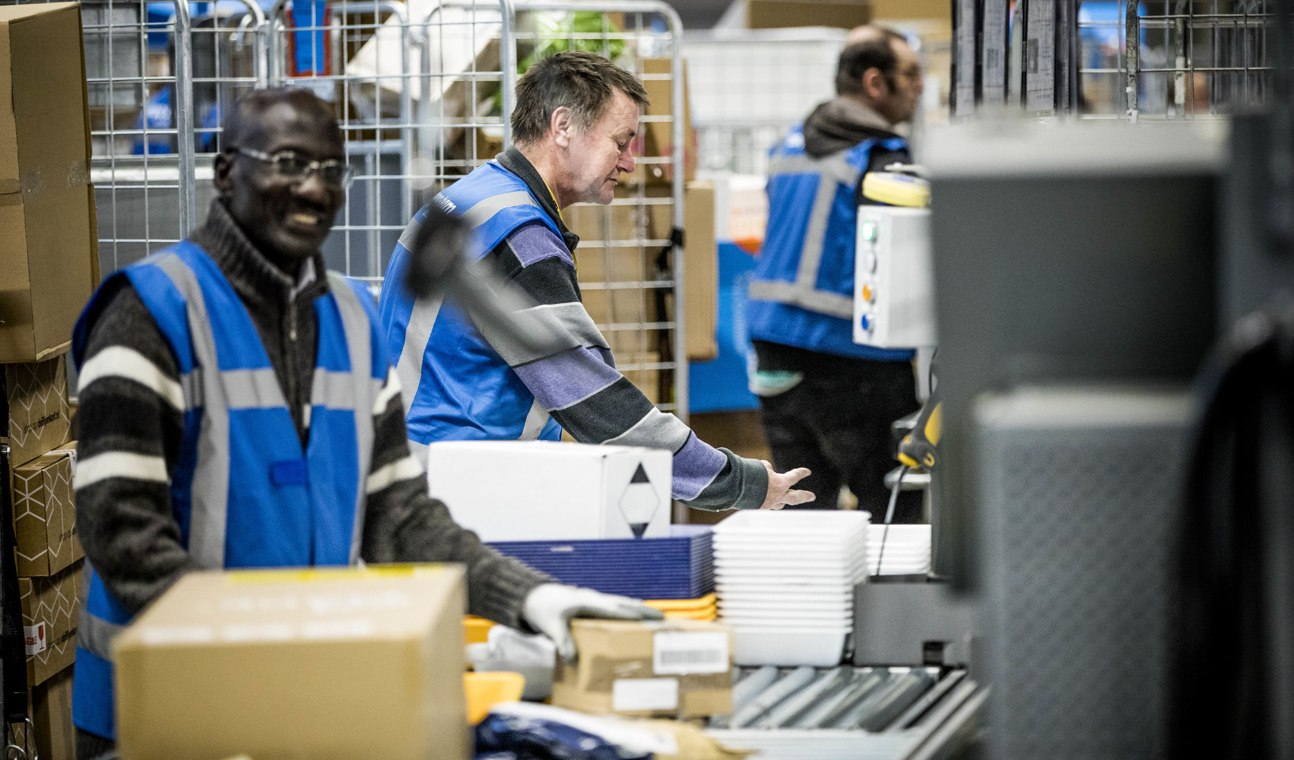Medewerkers van PostNL sorteren pakketjes in het sorteercentrum in Nieuwegein.