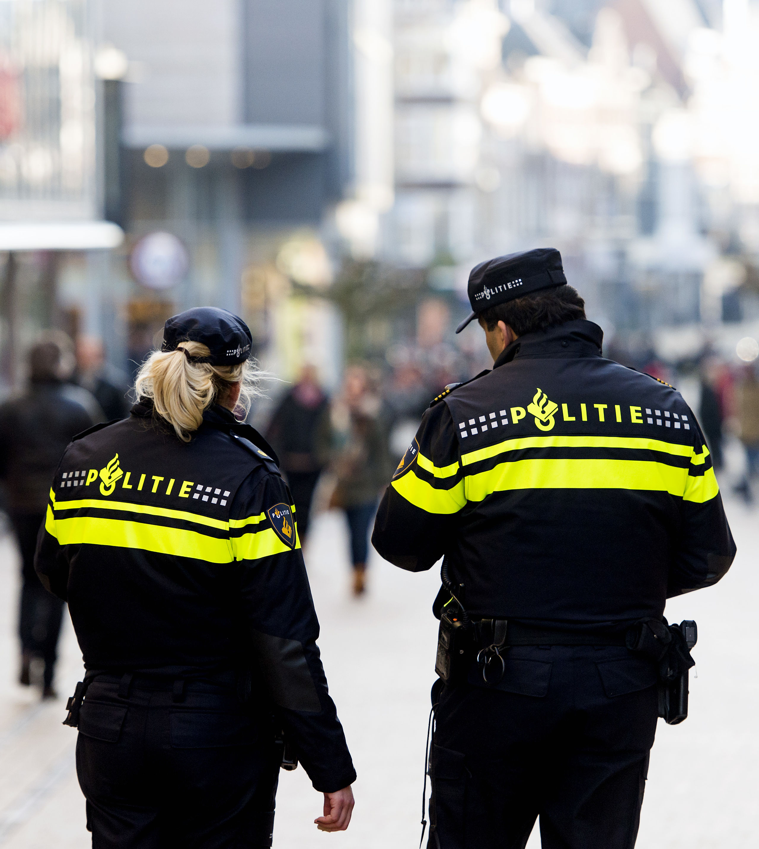 Politieagenten in operationeel uniform op straat. Politie, surveilleren, patrouille, winkelstraat, binnenstad. 