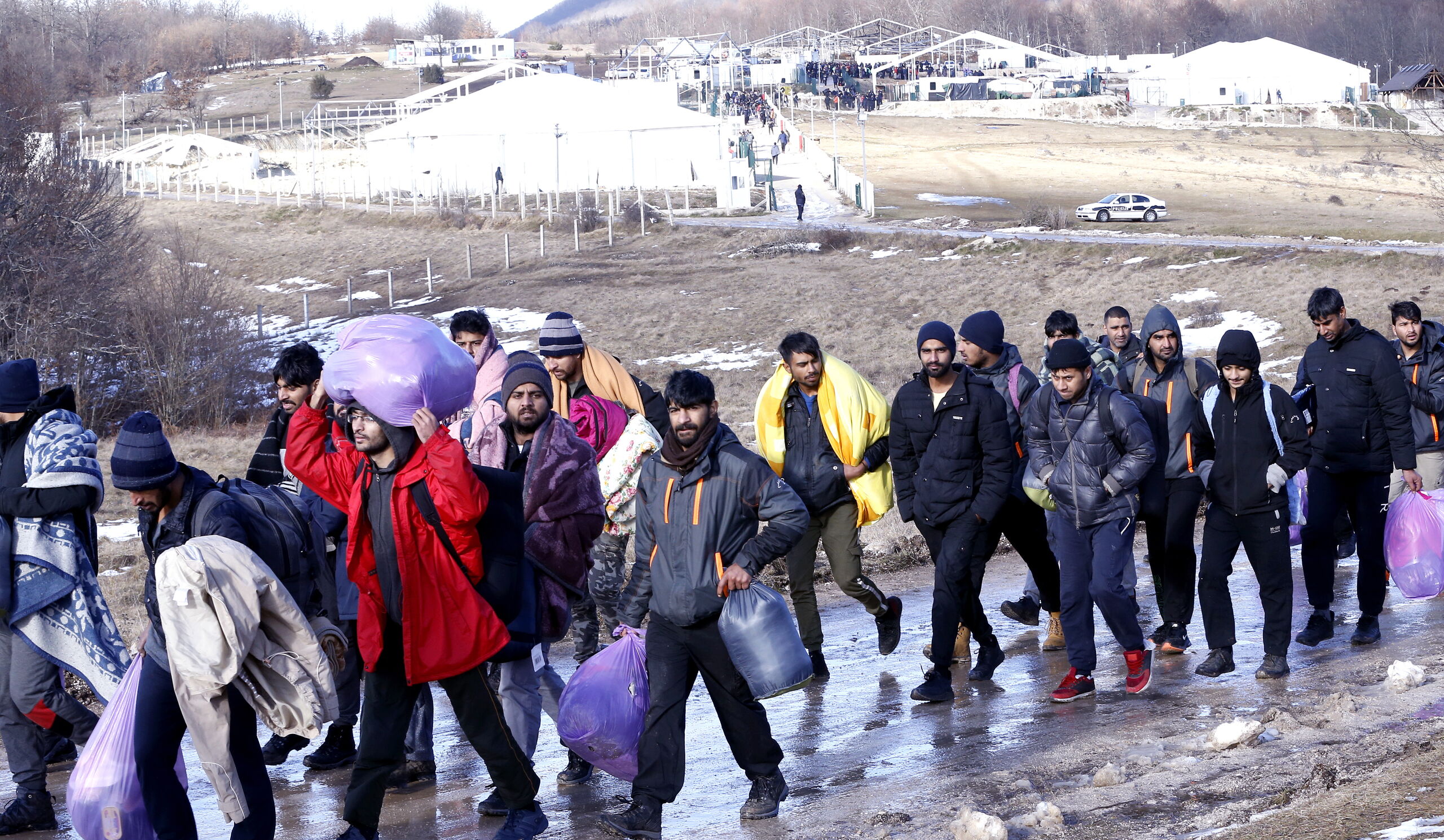 Vluchtelingen verlaten kamp Lipa bij Bihac, eind december. EPA/FEHIM DEMIR