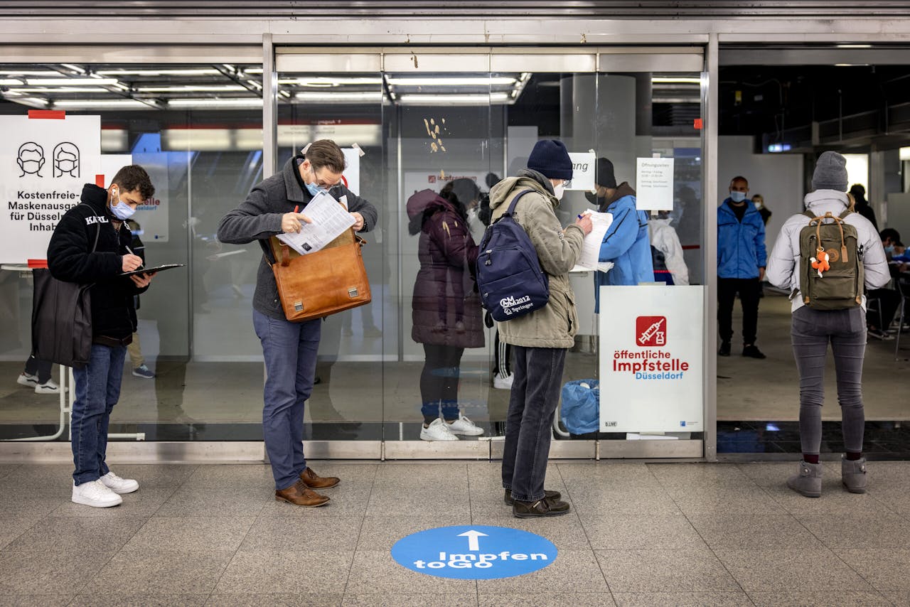 Mensen halen een boosterprik bij een metrostation in Düsseldorf