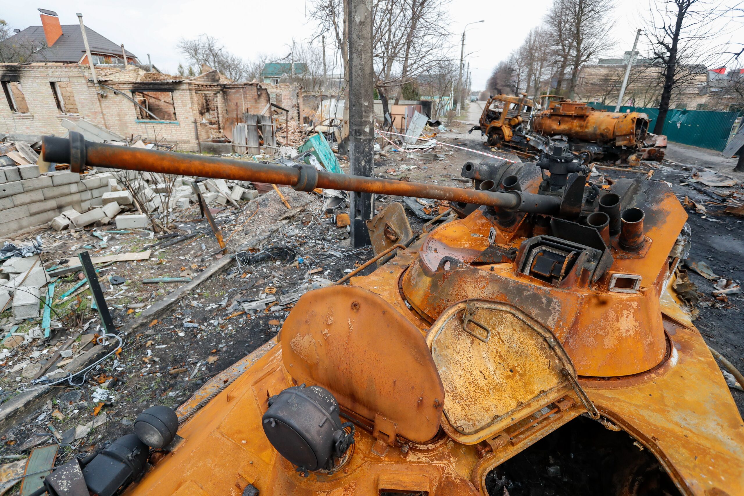 Verwoeste huizen en Russische militaire voertuigen in een stad boven Kiev waar de Russische soldaten zijn vertrokken. 
