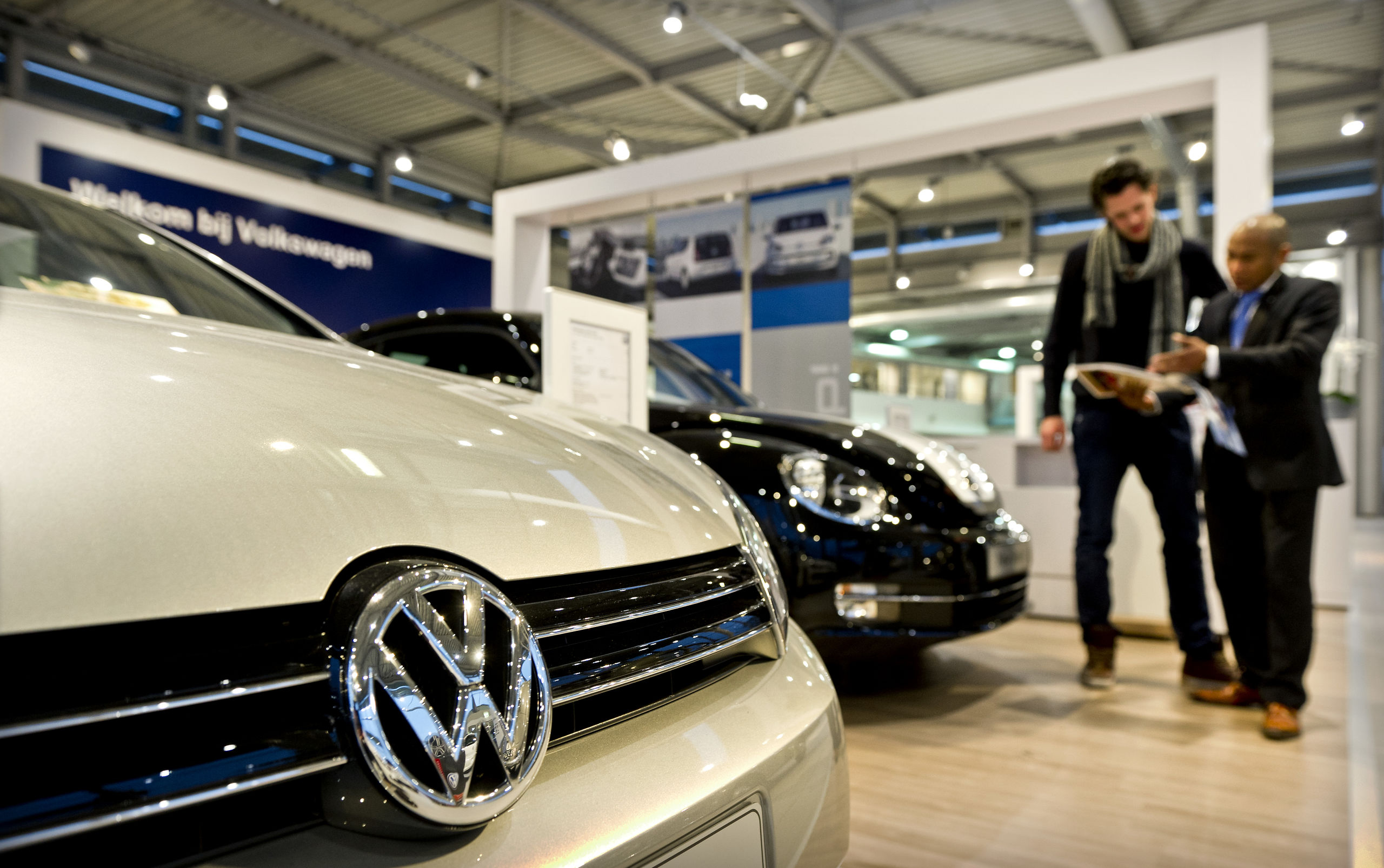 Een klant krijgt uitleg bij een VW dealer