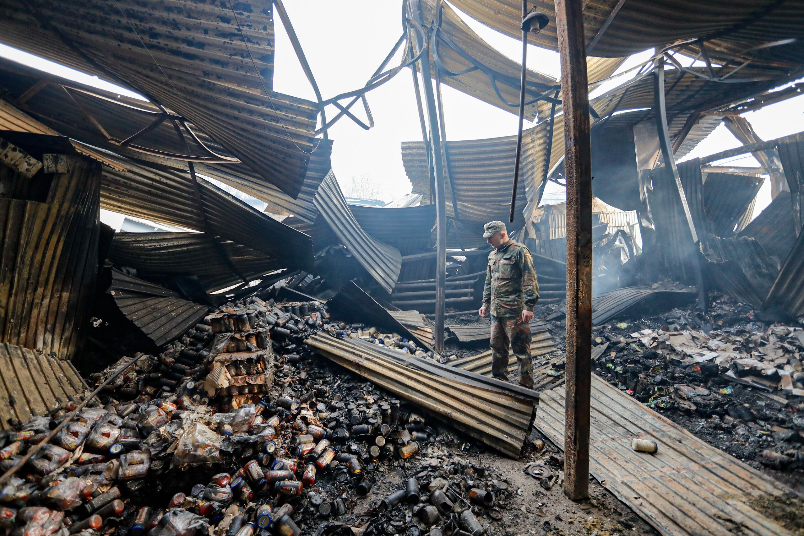 Een Oekraïense soldaat bekijkt de schade aan een voedselopslagplaats in de buurt van Kiev na een Russisch bombardement.