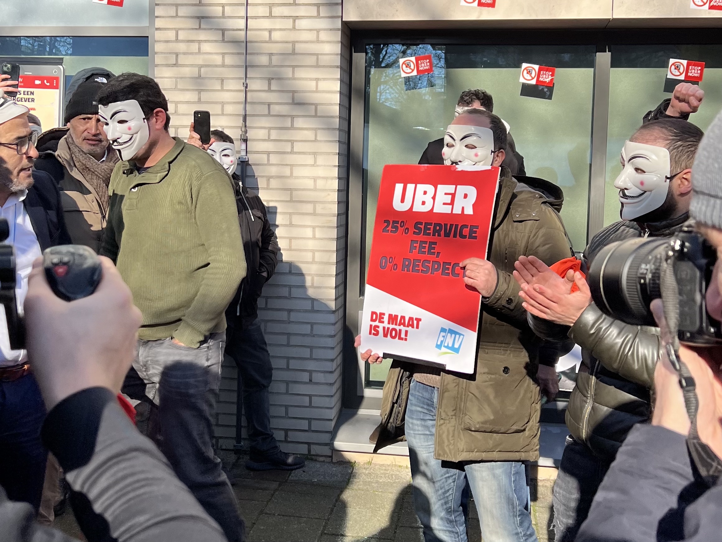 Zo'n honderd boze Uber-chauffeurs eisen bij het hoofdkantoor van de Amerikaanse taxi-app in Amsterdam een hoger salaris.