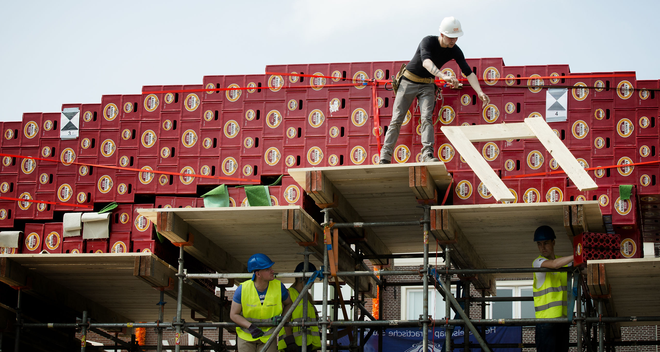 Studenten van de TU Delft bouwen een boogbrug van bierkratten.