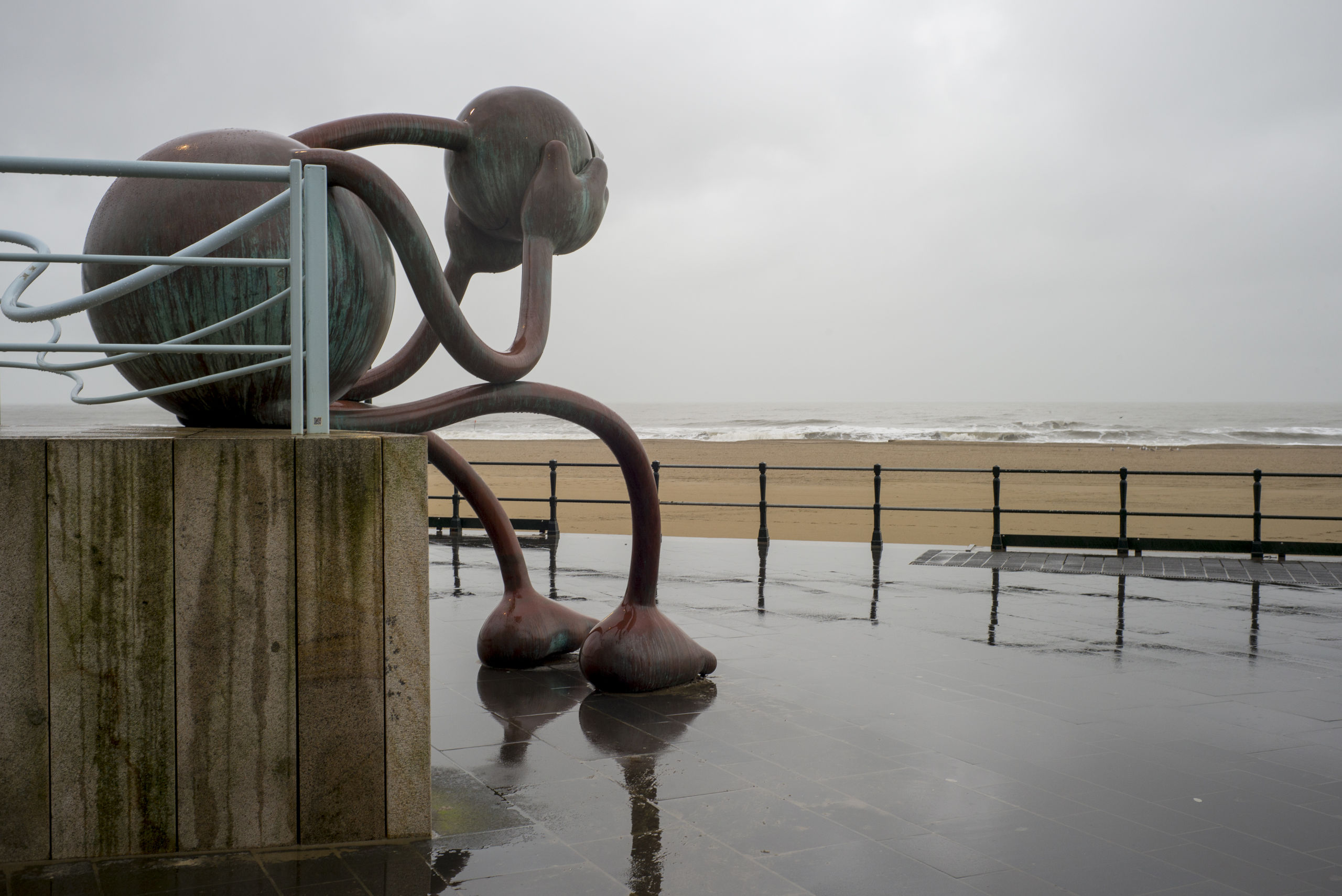 Het bronzen beeld 'Huilende reus' van de Amerikaanse beeldhouwer Tom Otterness, van museum Beelden aan Zee in Scheveningen op de boulevard.