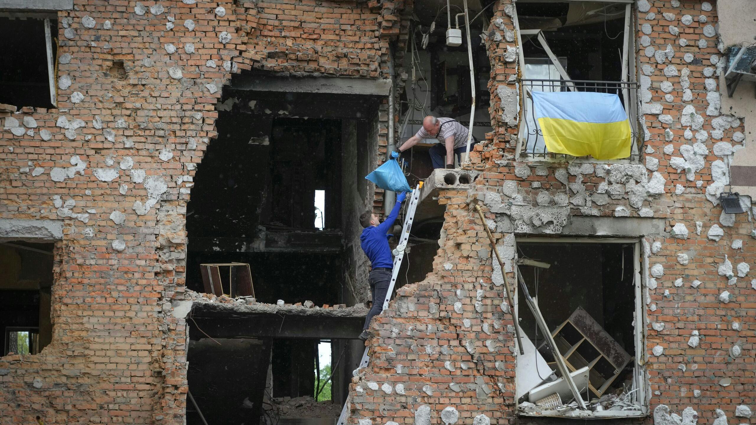 Bewoners halen hun bezittingen uit hun huis dat verwoest is door de Russische beschietingen in Irpin in de buurt van Kiev.