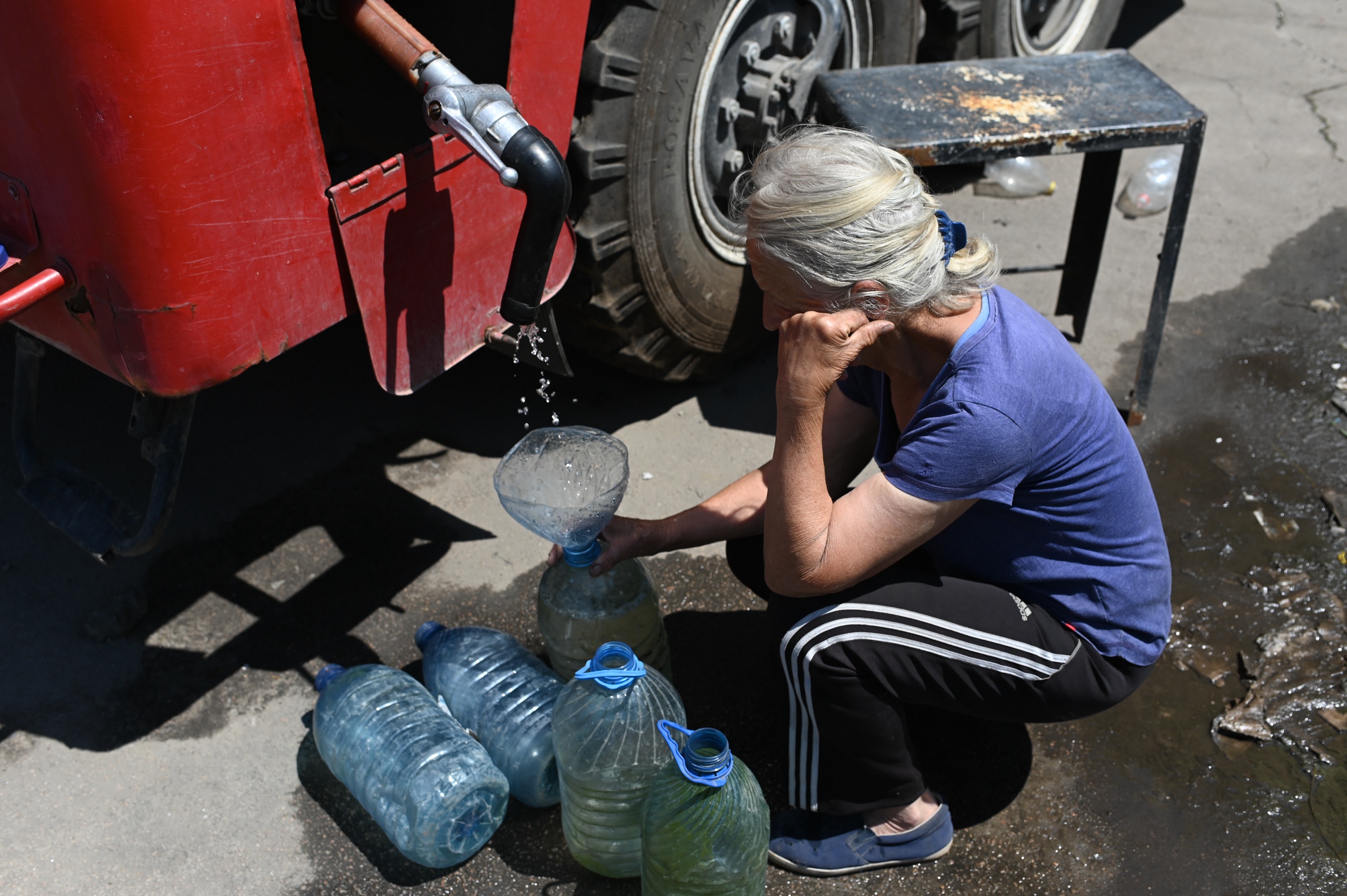 Inwoner van Lisitsjansk haalt water bij een brandweerauto