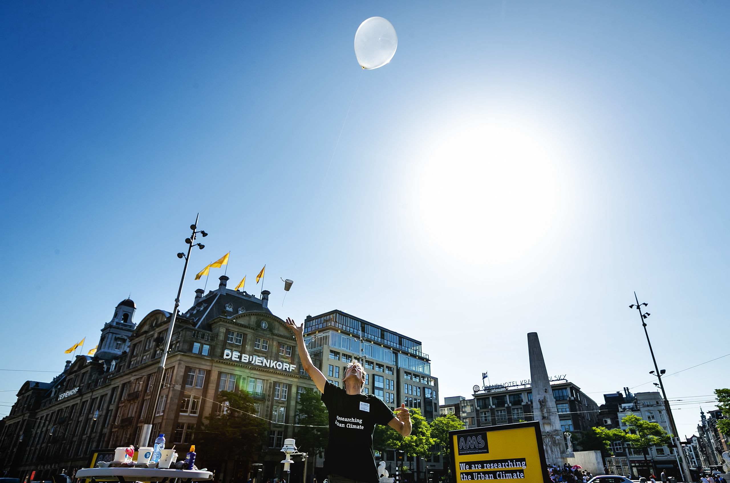 Onderzoekers van Wageningen Universiteit en AMS Institute laten een weerballon op vanaf de Dam.