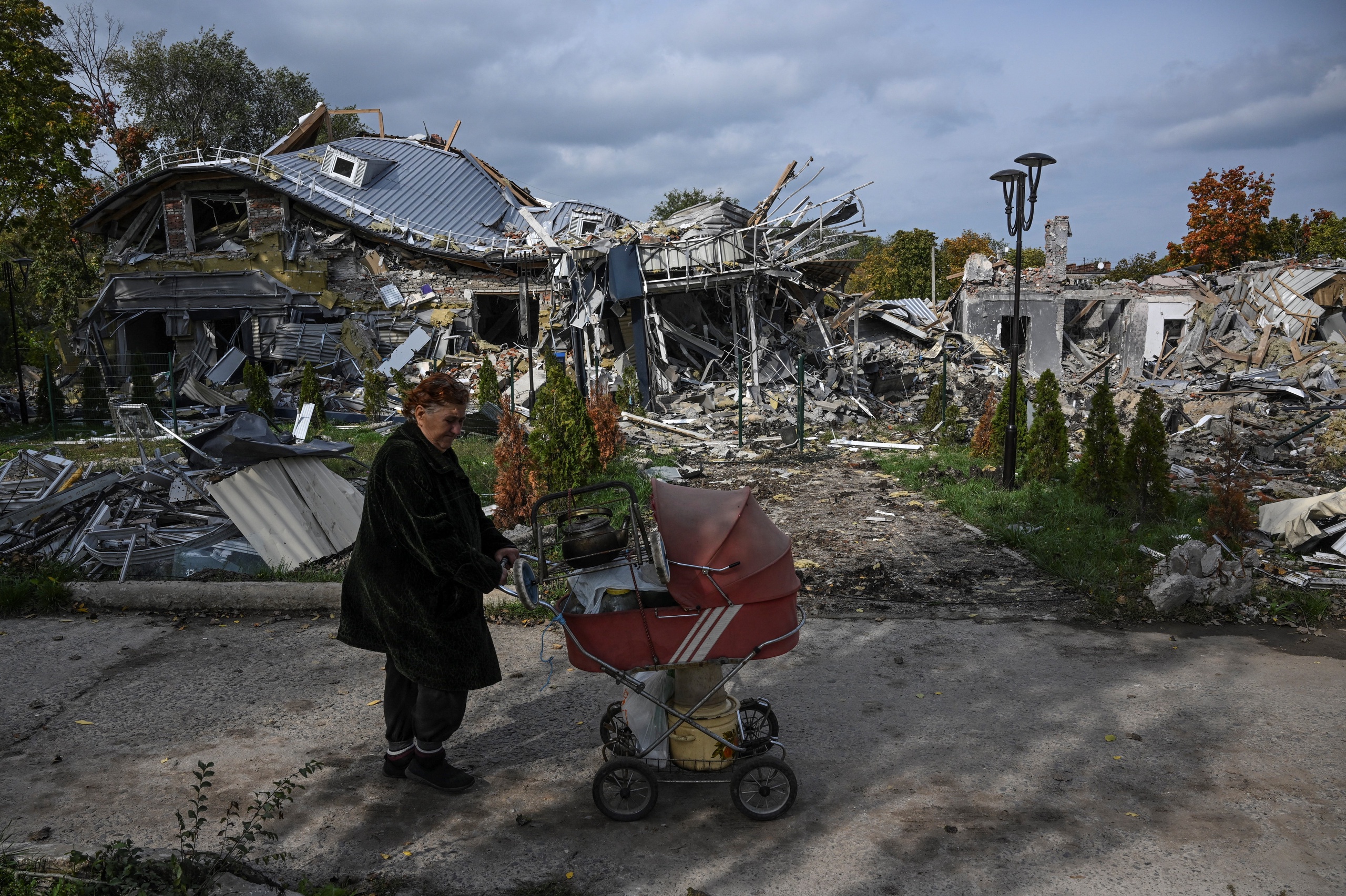 Een bewoner loopt langs een verwoest gebouw in Mykolaivka in Oost-Oekraïne.