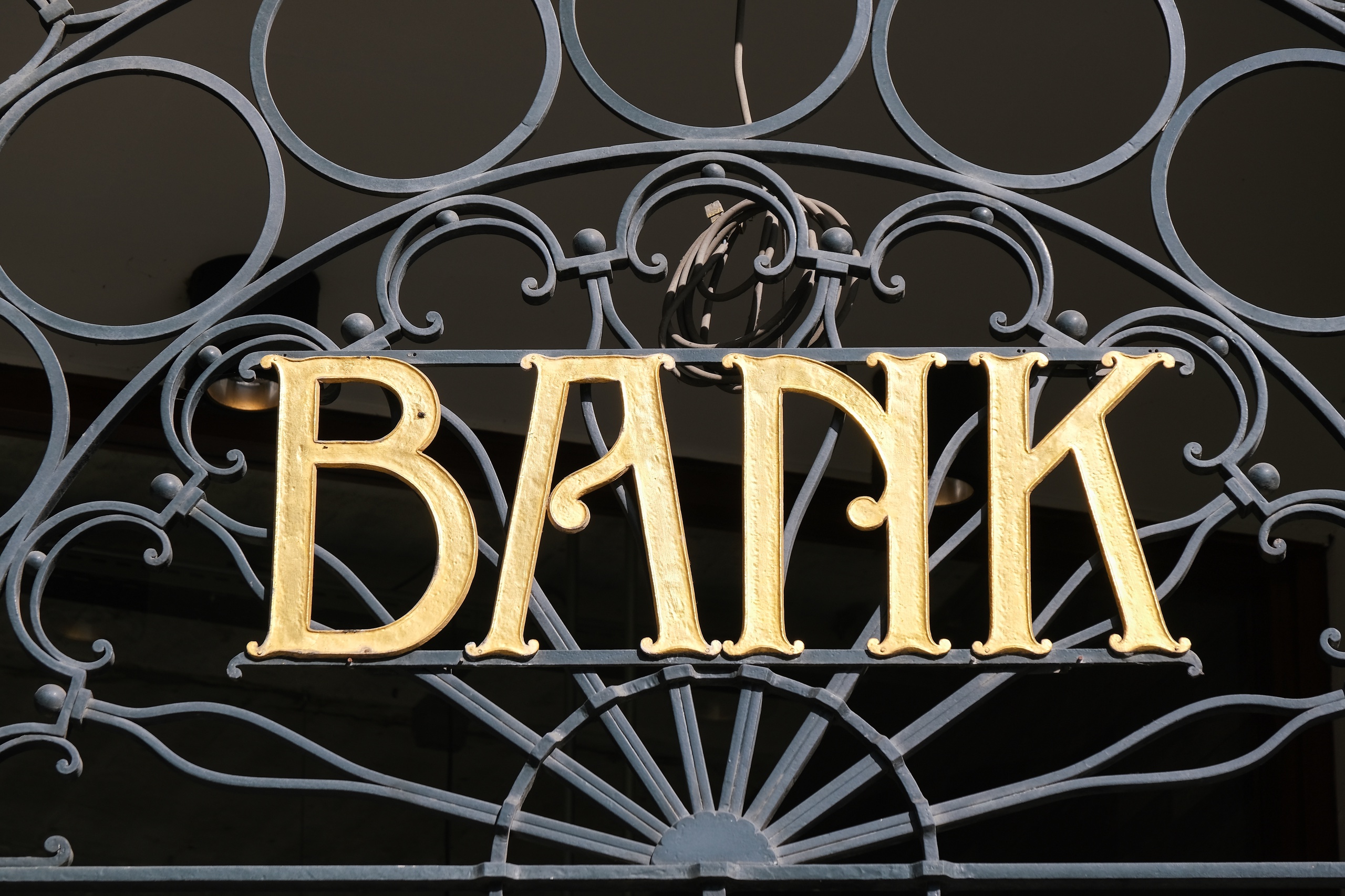 Nederland – Amsterdam. Goudkleurig logo van een voormalig bankfiliaal op het Damrak. Foto: ANP / Hollandse Hoogte / Kim van Dam