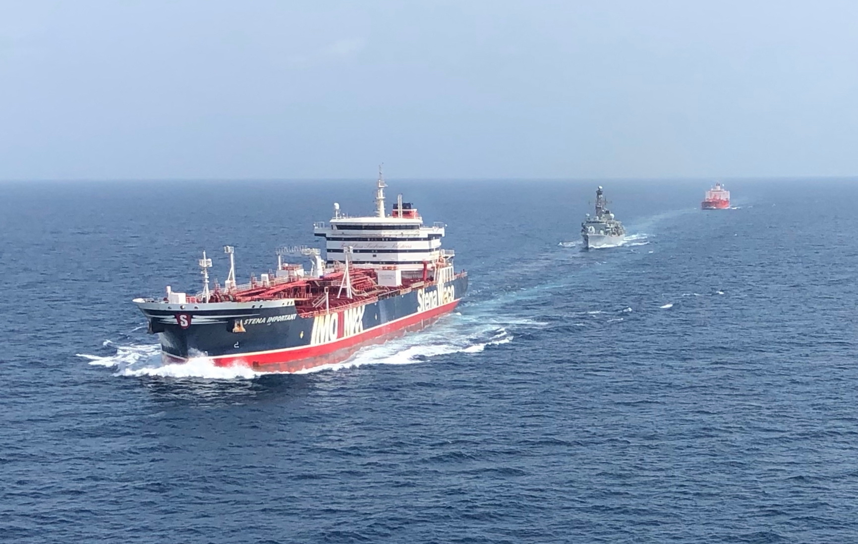 Een Brits fregat begeleidt twee vrachtschepen in de Straat van Hormuz.