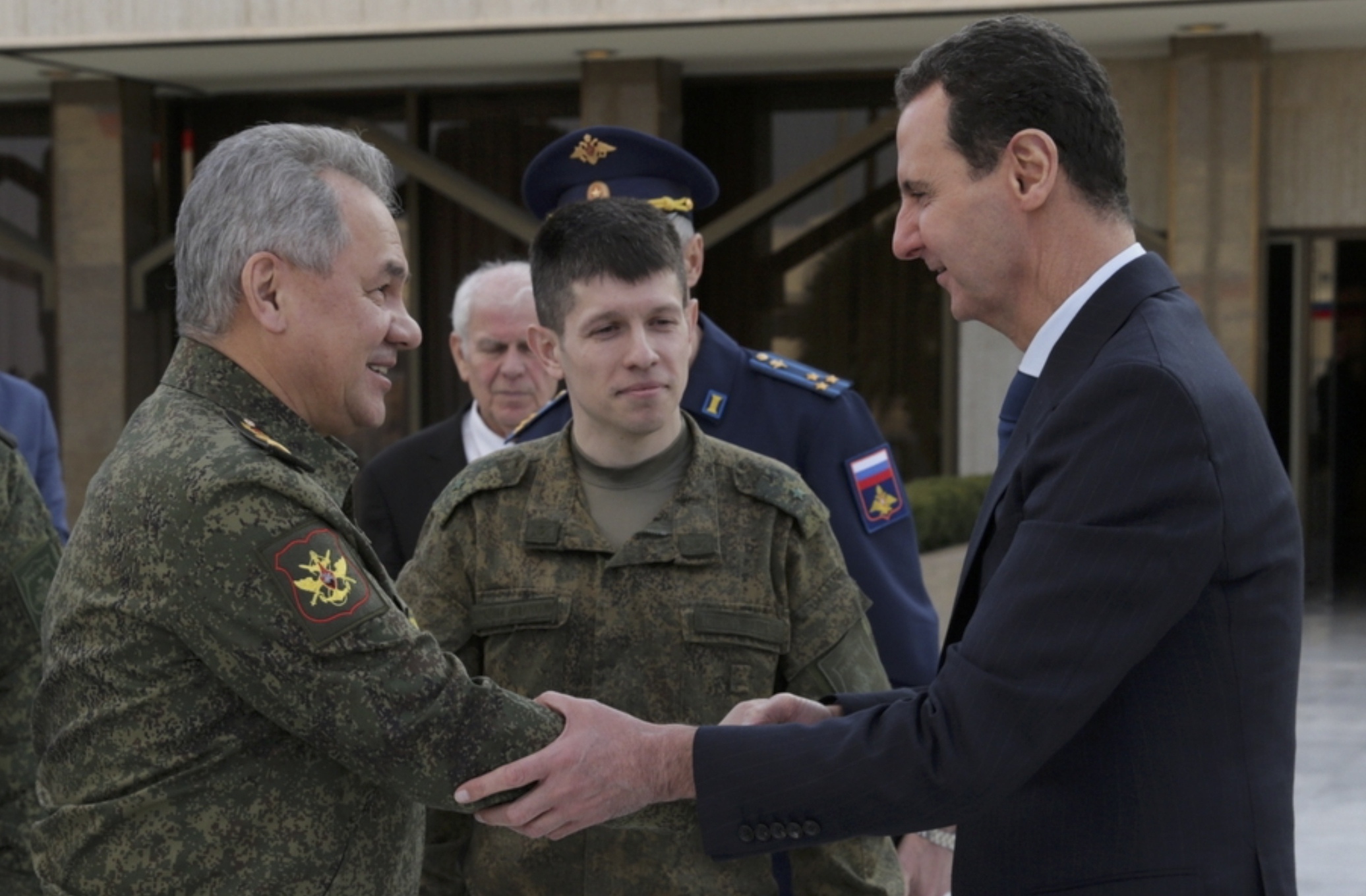 De Russische minister van Defensie Sergei Shoigu (l) schudt handen met de Syrische president Bashar al-Assad (r) in de Syrische hoofdstad Damascus op 15 februari 2022