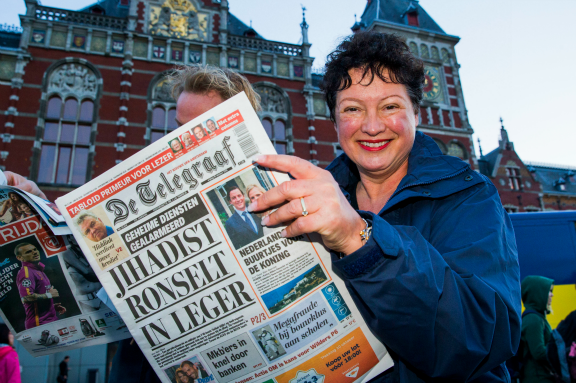 Journalist Wilma Nanninga deelde in 2014 de toen vernieuwde Telegraaf uit op Amsterdam CS. De meest tabloid krant van het land stapte als laatste landelijke krant over op het compacte formaat (Foto: ANP)