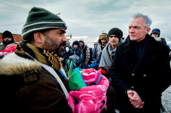 Kinderombudsman Marc Dullaert praat met vluchtelingen met kinderen tijdens een bezoek aan het vluchtelingenkamp Vinojug. Foto: ANP