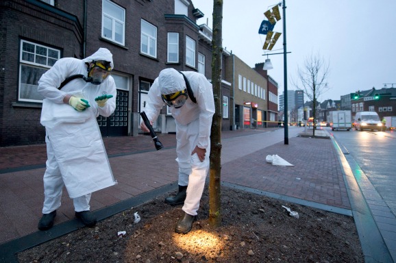 Twee mannen ruimen asbest op in Roermond nadat dit vrijkwam bij een grote brand in een loods in 2014. Foto: ANP