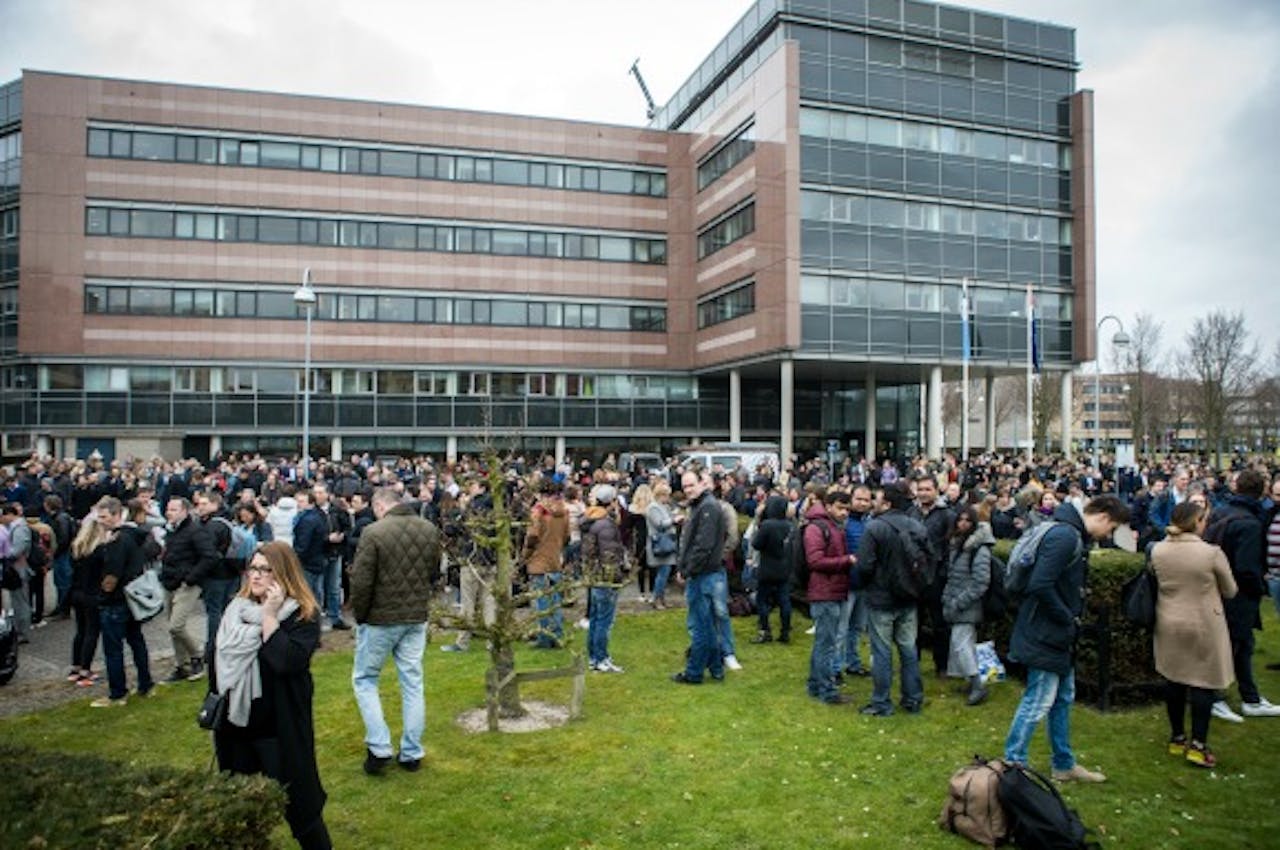 Medewerkers van uitgeverij Sanoma in Hoofddorp staan buiten na een ontruiming vanwege een bommelding. Foto ANP