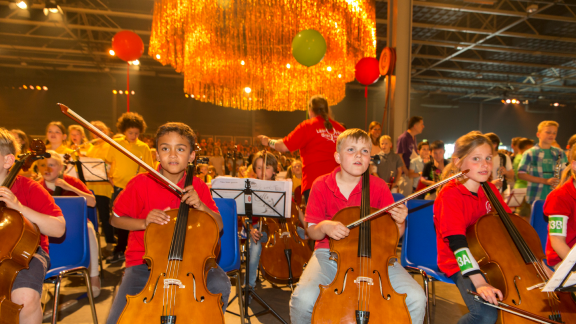 Kinderen musiceren tijdens de tweede editie van het eindconcert van Kinderen Maken Muziek, juni dit jaar. Dit initiatief biedt zoveel mogelijk kinderen de mogelijkheid in aanraking te komen met een muziekinstrument en samen muziek te maken. Bij dit concert was ook koningin Máxima aanwezig.