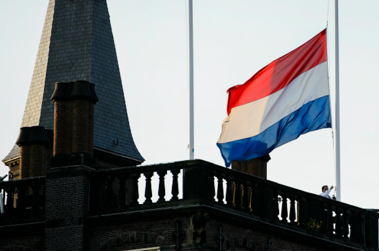 Foto: ANP - De vlag op het Binnenhof hangt halfstok ter nagedachtenis aan de slachtoffers