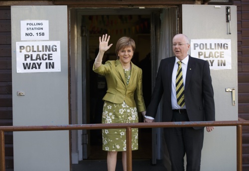 SNP-leider Nicola Sturgeon en haar man Peter Murrell verlaten het stembureau. EPA
