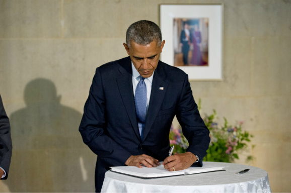 Obama tekent het condoleanceregister voor de slachtoffers