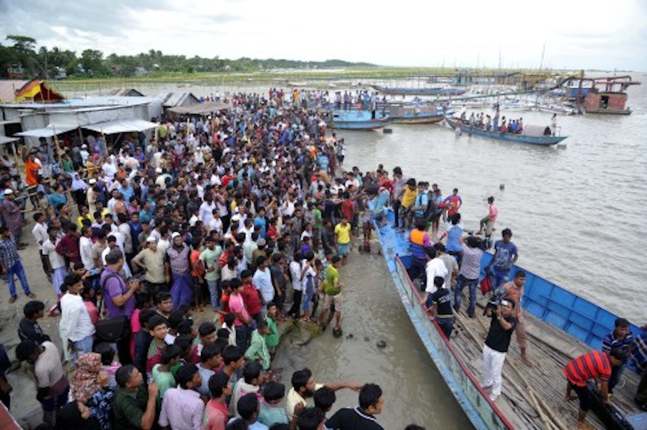 Nabestaanden verzamelen zich bij de rivier de Padma vlak na de ramp. EPA
