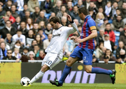 Gonzalo Higuain (L) van Real Madrid in duel met Sergio Martinez Ballesteros (R) van Levante. EPA